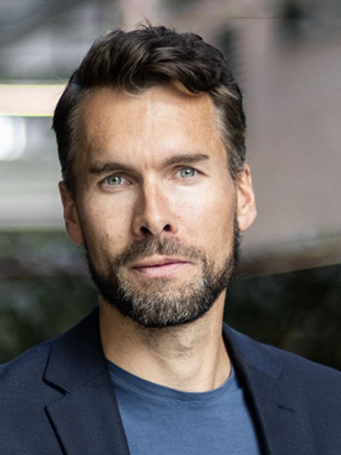 Bilde av ung, alvorlig mann i dress med mørkt hår
